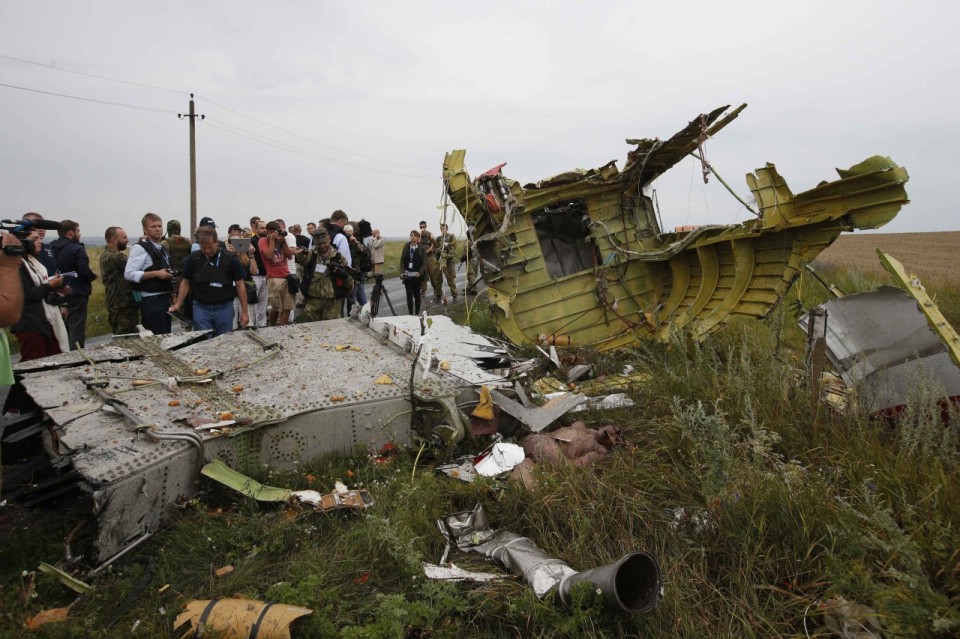 OSCE monitors and pro-Russian separatists stand at the crash site of Malaysia Airlines flight MH17, near the settlement of Grabovo in the Donetsk region
