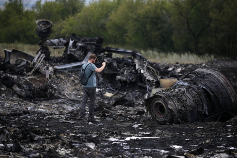 A journalist takes photographs at the site of Thursday's Malaysia Airlines Boeing 777 plane crash near the settlement of Grabovo, in the Donetsk region